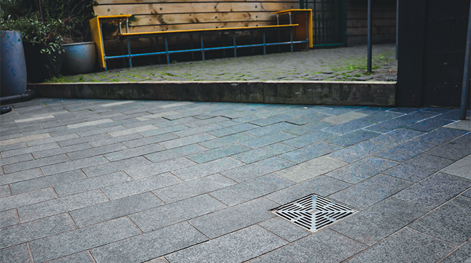 Allproof Podium Drain with bronze body and storm series grate for commercial drainage