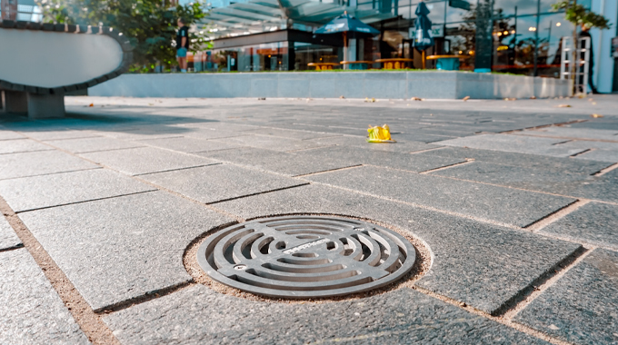 Allproof Podium Drain with bronze body and storm series grate for commercial drainage