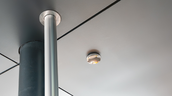 Stainless steel soffit cover for overflow pipe exit