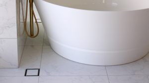 InvisiDrain-tile-insert-drain-grate-next-to-bath-floor-overflow-drain-product-slider